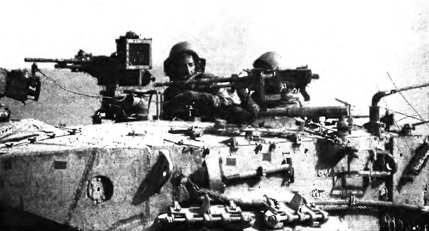 The tank commander and loader in their places in the tower hatches. The view from the left side.