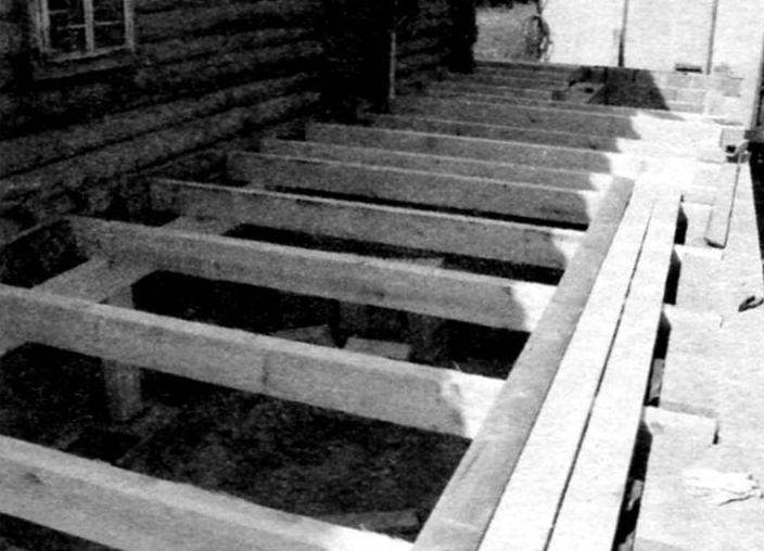 Wooden beams-joists under the flooring on the porch was laid during construction before construction of the walls