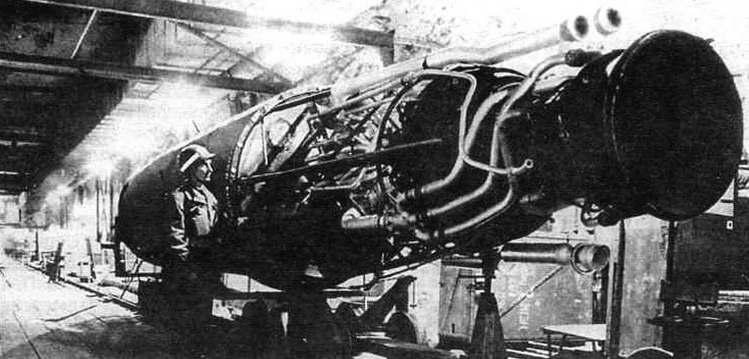 Силовая установка «Фау-2». Можно оценить размеры двигателя. Две трубы сверху - дренаж кислорода и выхлоп ТНА, рядом с солдатом - реактор или бак катализатора. Снимок сделан американскими специалистами на заводе «Дора»