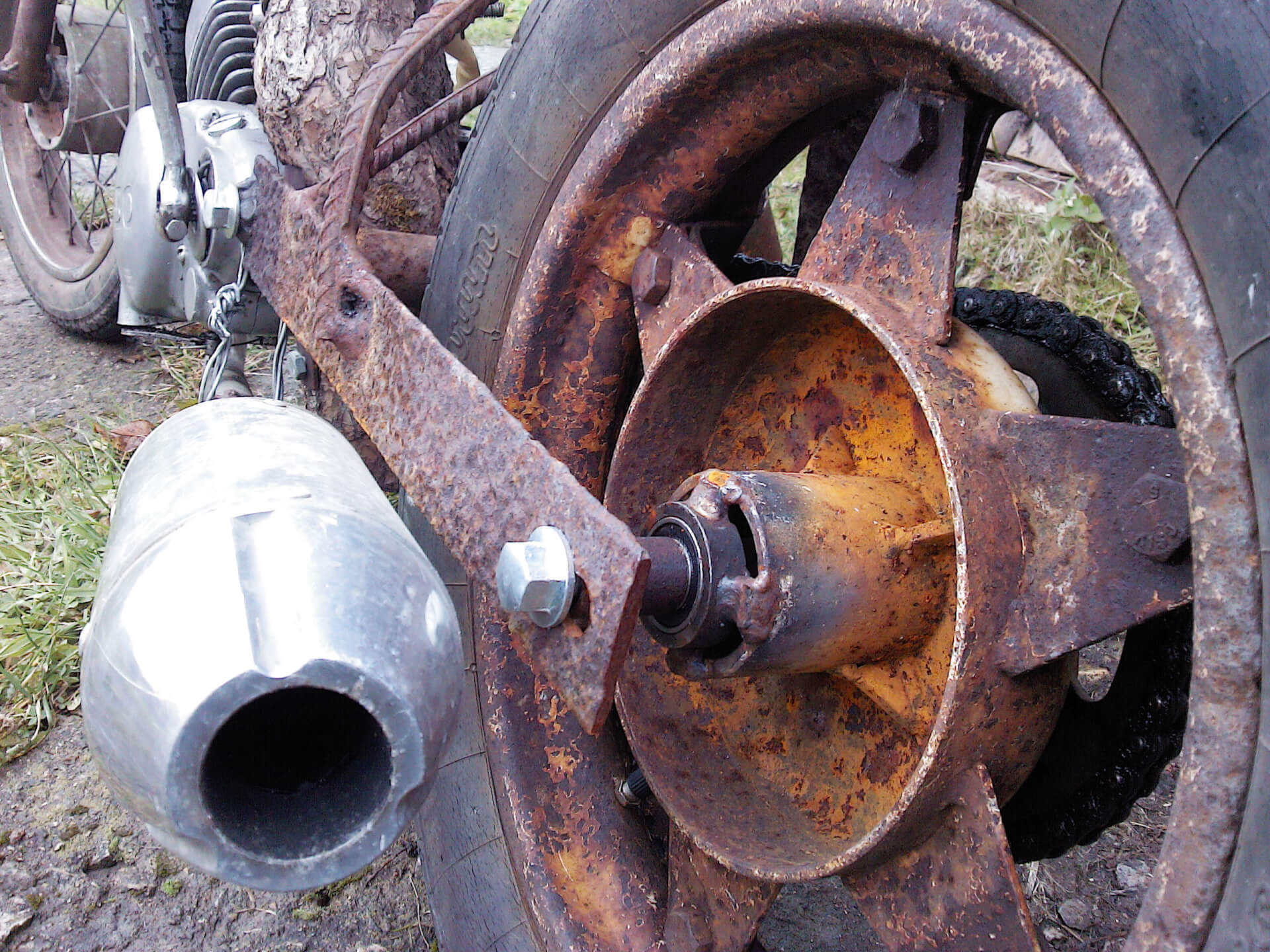 Качающийся маятник и диск колеса выполнены в одном стиле -из металлического хлама