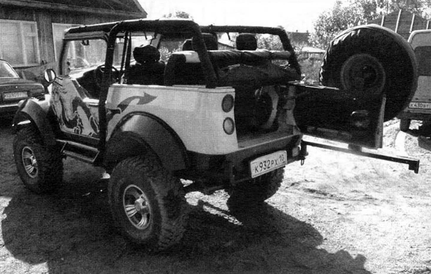 Rear swinging door on a mono-hinge and a spare wheel on a rotating console (“wicket”)