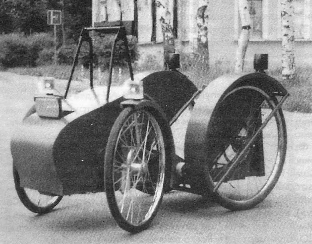 The headlight is raised, the parking lights are on. The drive is visible: the chain drive and the sprocket of the leading left rear wheel