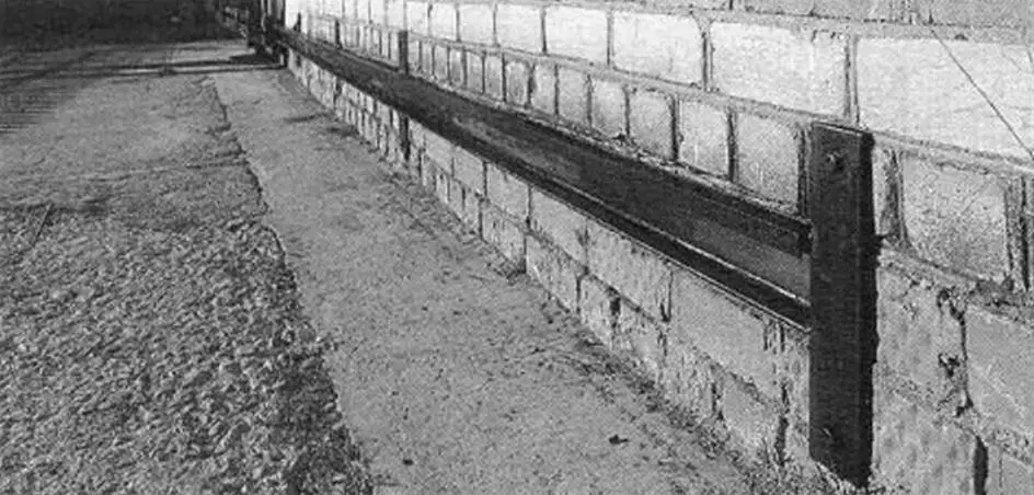Guide channel attached to brick veranda wall with dowels through plates welded to the channel