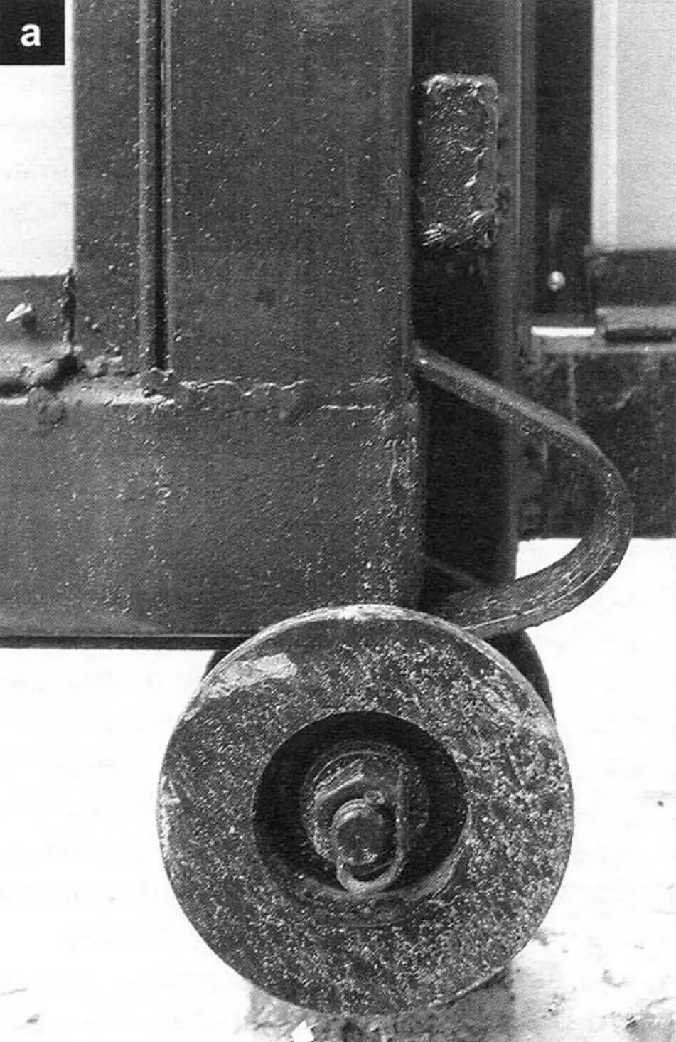 In closed position (see header) the gate frame is additionally held by the lower roller (a) on the left intermediate support post and upper bolt (b); gate travel is limited by a bolt resting against the upper retaining roller (c)