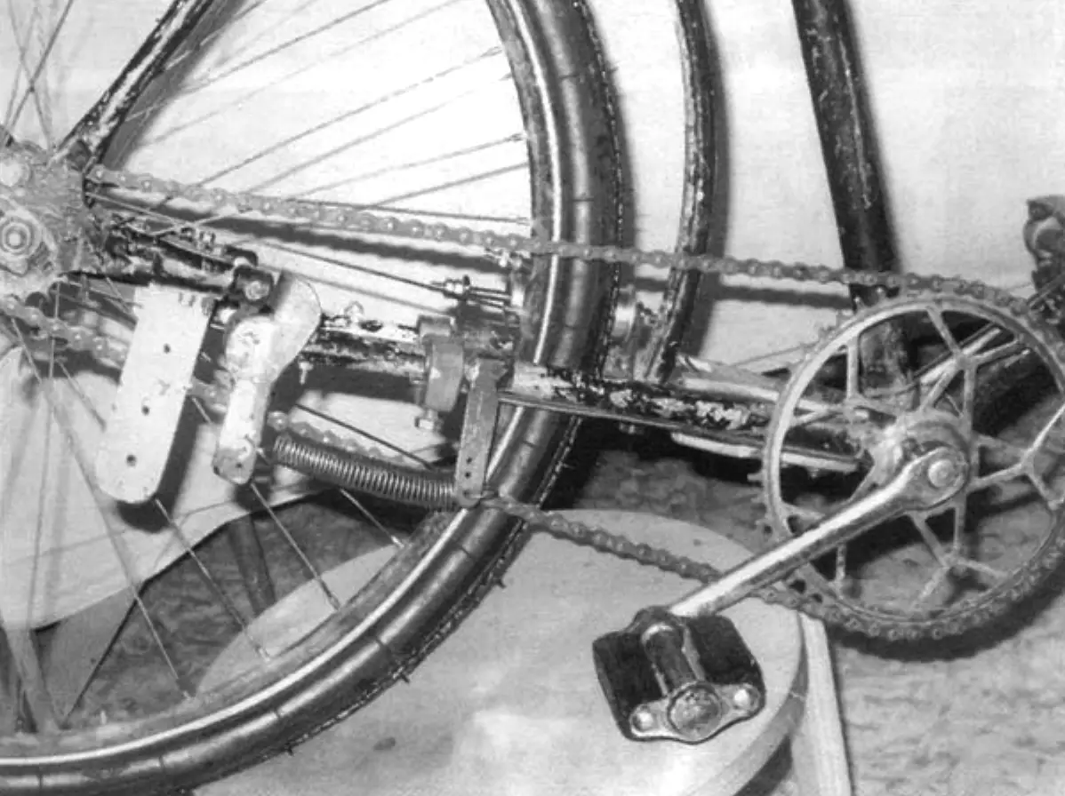 View of the two-hinge mechanism from the right side. Here the chain guide, two-arm lever with spring and bracket are mounted.