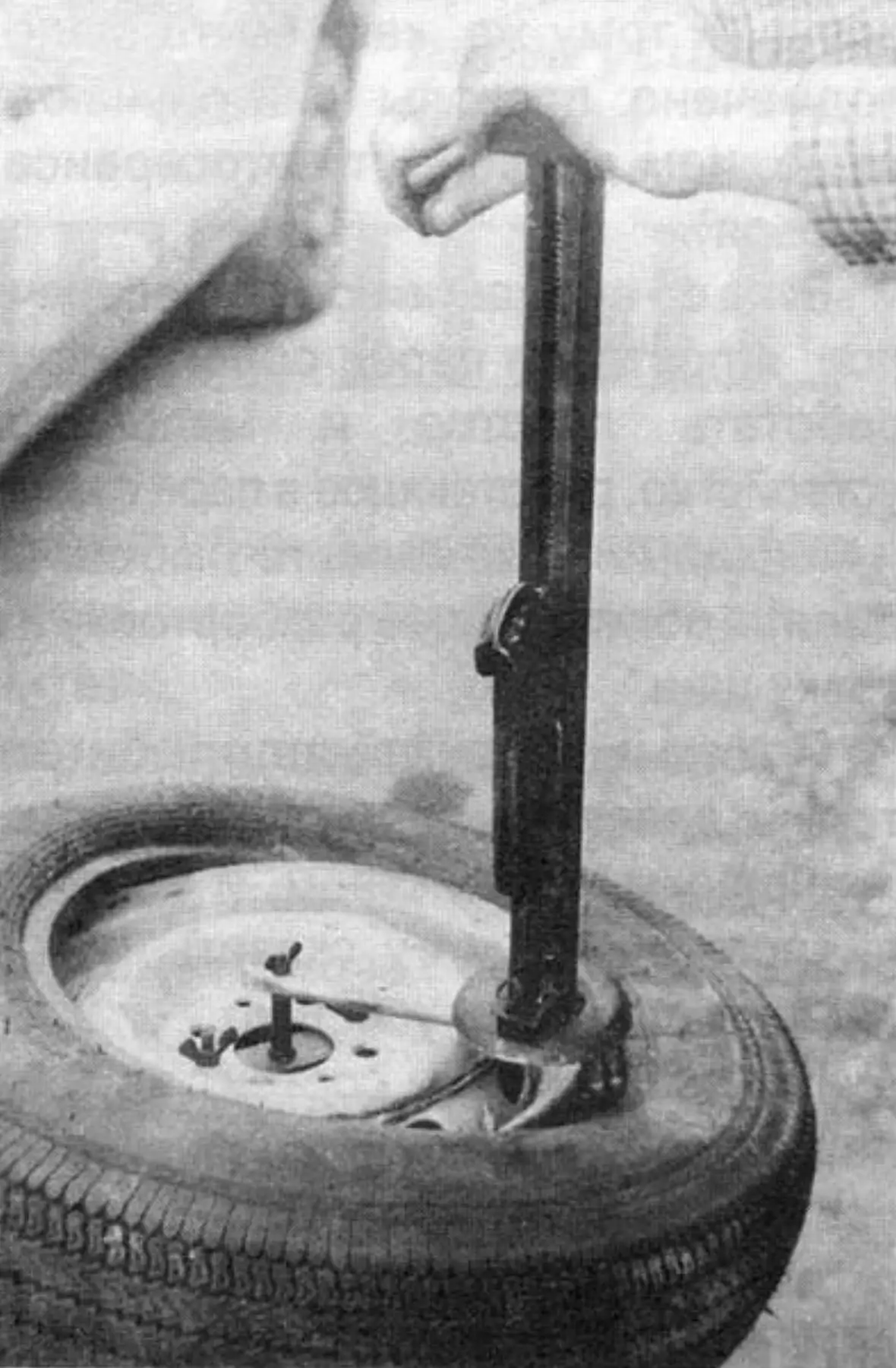 Tire mounting process on the wheel rim using the fixture with the stock jack and lug wrench (hidden behind the tire bead)